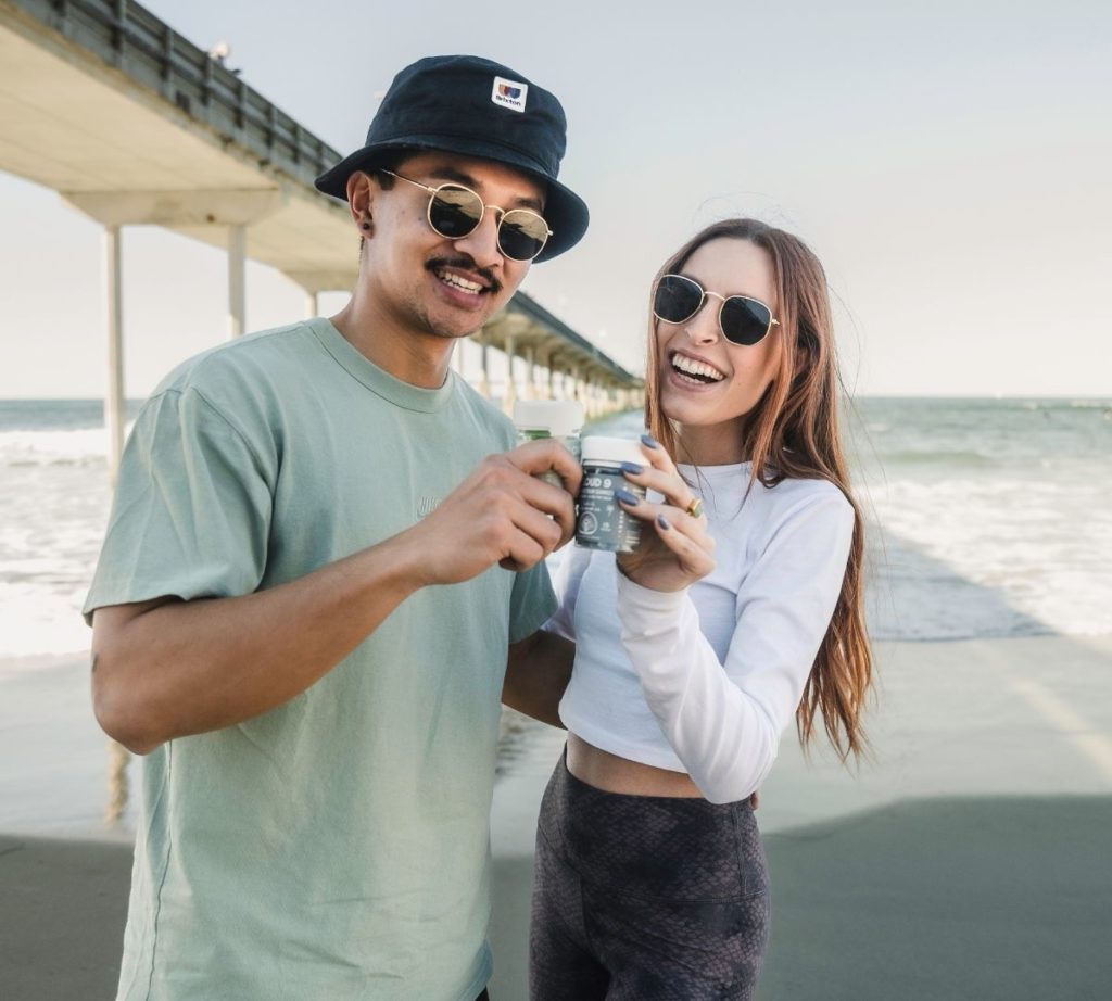 Couple holding THC Gummies at the beach